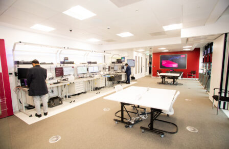 The SONIC Labs facilities. A line of computers on the left hand side leading to a server room. On the right are large tables for collaborative working