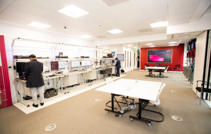 The SONIC Labs facilities. A line of computers on the left hand side leading to a server room. On the right are large tables for collaborative working